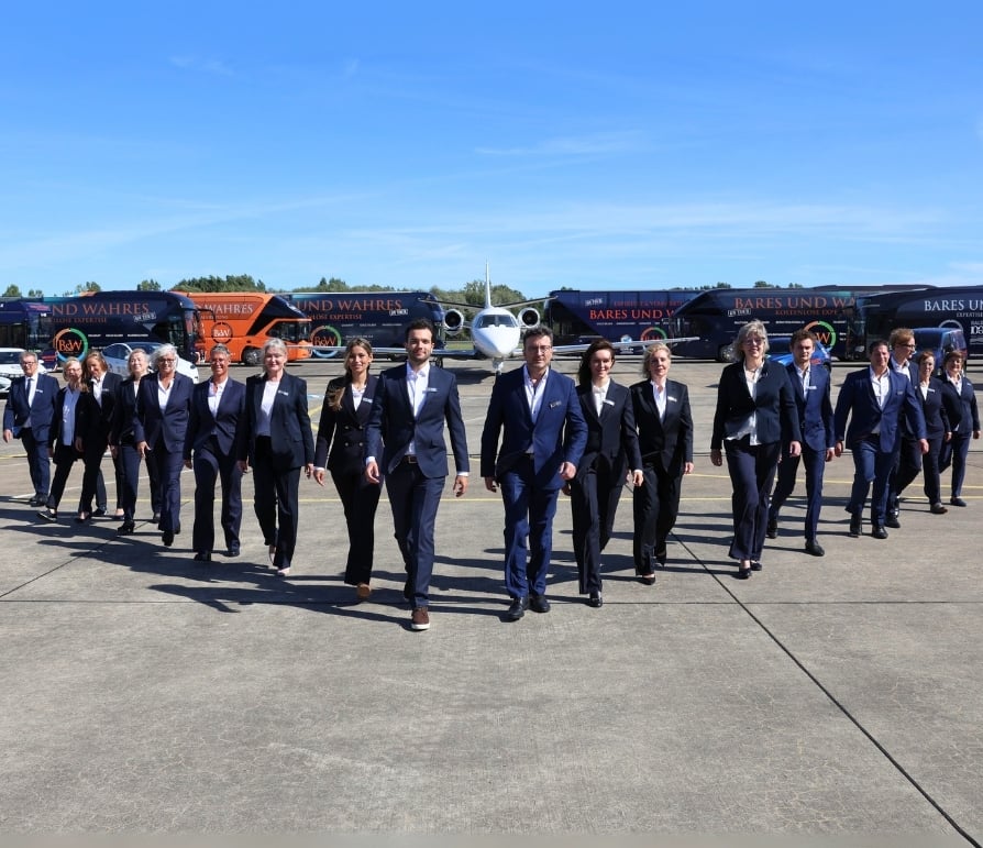 Team foto met bussen en jet